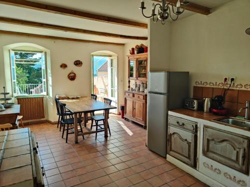 une cuisine avec une table et une salle à manger dans l'établissement Les Tilleuls, à Olmi-Cappella