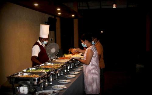 a couple of people standing in front of a buffet at Athyantha Resort in Anuradhapura