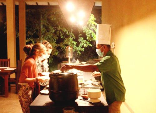 a man in a chefs hat preparing food in a kitchen at Athyantha Resort in Anuradhapura