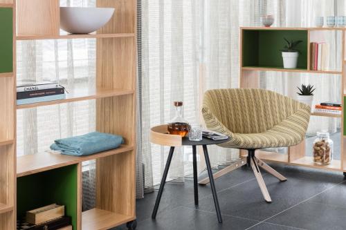 a chair and a table in a room with shelves at Wittenberg by Cove in Amsterdam