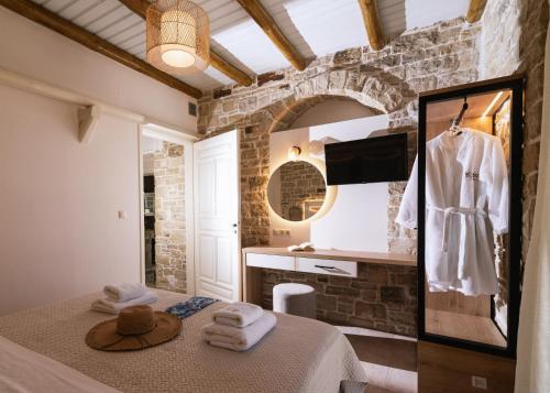 a bathroom with a bed in a room with a mirror at Koronio Villas in Kalamaki