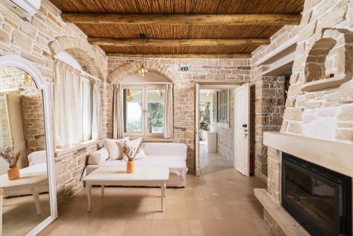 a living room with a fireplace and a stone wall at Koronio Villas in Kalamaki