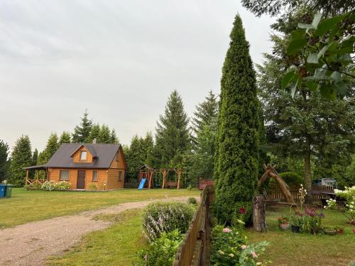 a house in a garden with a playground at Agroturystyka Katarzyna Tarasiewicz in Stary Folwark