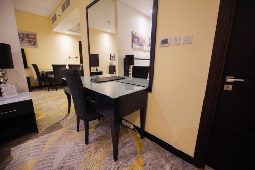 an office with a desk with chairs and a mirror at Grand Villaggio Hotel Abu Dhabi in Abu Dhabi