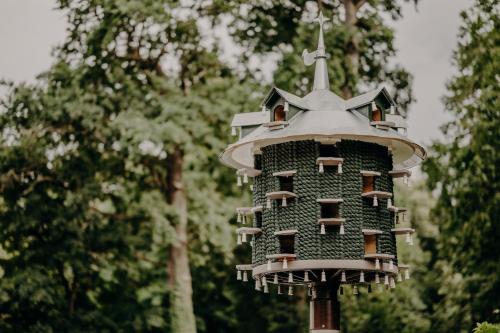 a bird house on a pole with trees in the background at Kleines Schloss Lanke in Wandlitz