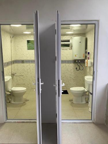 a bathroom with two toilets and two sinks in a room at Guest House Mariami in Ushkhvanari