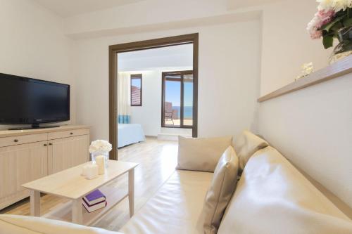 a living room with a couch and a tv at Hotel Dei Pini in Alghero
