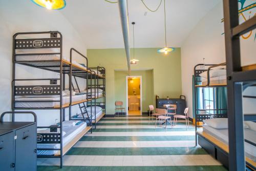 a room with bunk beds and a table and chairs at Ostello Bello Palermo in Palermo