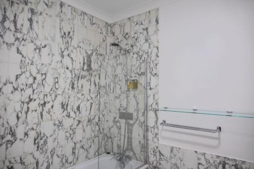 a bathroom with a black and white tiled wall at Woodland Manor Hotel in Bedford