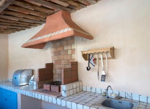 une cuisine avec une cuisinière et un comptoir dans l'établissement T3 indépendant dans villa Piscine Privée Vue Mer panoramique très calme 4personnes, à Porto-Vecchio