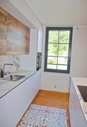 une cuisine avec un évier et une fenêtre dans l'établissement Superbe appartement sur la plage, à Conjux