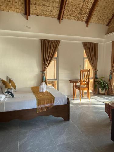 a bedroom with a bed with a chair and a table at Brazaville Beach Resort in Hinoba-an