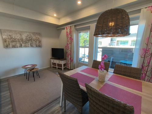 a dining room with a table and chairs and a television at Hilmantori Apartments by Hiekka Booking in Kalajoki