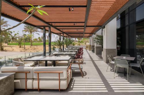 a row of tables and chairs on a patio at The G Einbay Golf Resort in Ain Sokhna