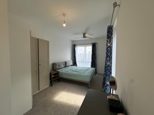 a living room with a bed and a window at Beautiful Newbuild 5 bedroom Town House in Chelmsford