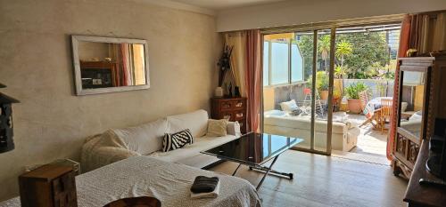 un salon avec un canapé et une table en verre dans l'établissement Appartement Angela, au Golfe-Juan