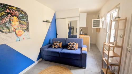 - un canapé bleu dans un salon avec un mur bleu dans l'établissement Studio *Sérénité*, à Villejuif