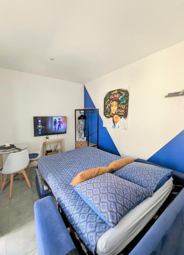 une chambre avec un lit bleu et blanc et un bureau dans l'établissement Studio *Sérénité*, à Villejuif
