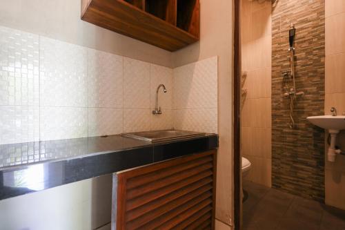 a small bathroom with a sink and a shower at RedDoorz near Mertasari Beach 2 in Pesanggaran
