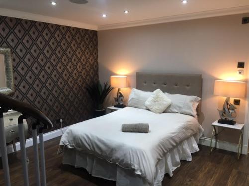 a bedroom with a large white bed with two lamps at Brig O'Doon 1 in Ayr