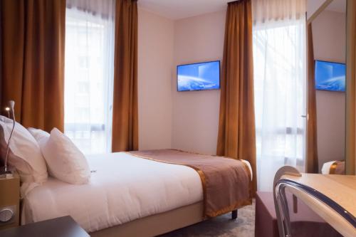 a hotel room with a bed and a window at Hotel Sixteen Paris Montrouge in Montrouge