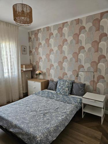 - une chambre avec un lit et un mur avec un motif dans l'établissement Appartement rénové dernier étage en ville et au calme, à Toulon