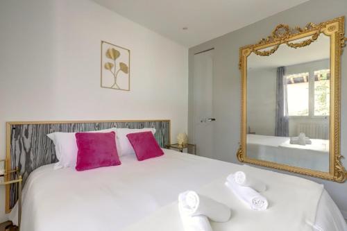 - un lit blanc avec des oreillers roses et un miroir dans l'établissement L’Ostalet ~ Parking ~ Jardin ~ Rangueil, à Toulouse