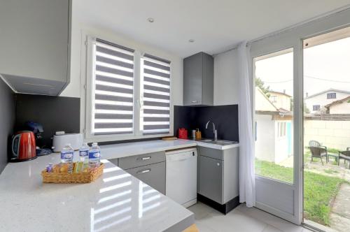 d'une cuisine avec un comptoir, un évier et une fenêtre. dans l'établissement L’Ostalet ~ Parking ~ Jardin ~ Rangueil, à Toulouse