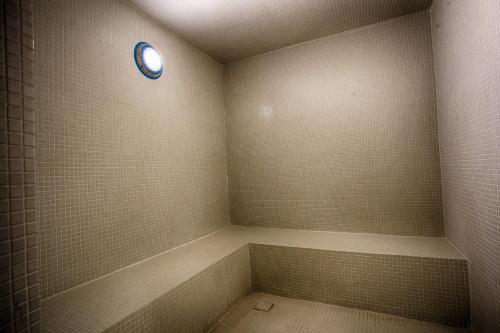 a bathroom with a shower with a blue clock on the wall at Al Faris Suites 2 in Juffair