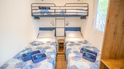 a small room with two beds in a tiny house at Happy Camp mobile homes in Camping Bella Italia in Peschiera del Garda