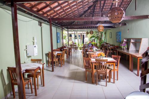 un restaurante con mesas y sillas de madera y una cafetería en Pousada Cavalo Marinho, en Abraão