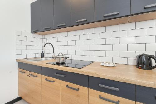 une cuisine avec un évier et un plan de travail dans l'établissement Wyspiańskiego Bright & Comfortable Apartment with a Sea View Gdynia by Noclegi Renters, à Gdynia