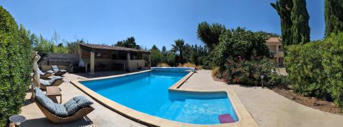 une piscine avec des chaises et une maison dans l'établissement Le Gîte d'Entressen studio Piscine Jeux & Pétanque Istres Miramas, à Entressen