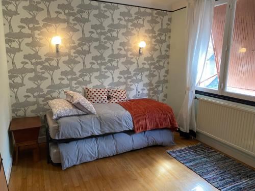 - une chambre dotée d'un lit avec un mur à motifs dans l'établissement Maison de ville avec jardin, à Malestroit