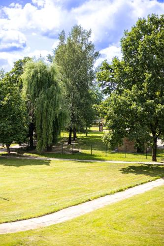 a park with trees and a path in the grass at ᴄᴏʜᴏsᴛ I 2BD Apartment With Balcony in Mažeikiai