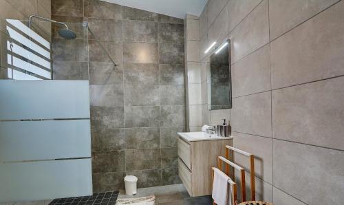 a bathroom with a shower and a sink in it at Leu Burgot 2 - 3 étoiles - T3 - Front de mer & centre ville - Appt 17 in Saint-Leu