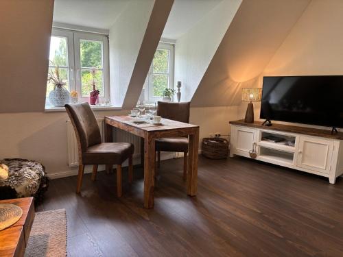 un soggiorno con tavolo e TV a schermo piatto di 4 wunderschöne Ferienwohnungen im Kavaliershaus a Schwerin