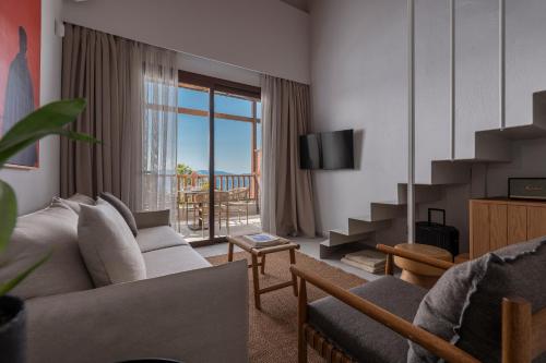 a living room with a couch and a tv at Anima Residence in Nea Roda