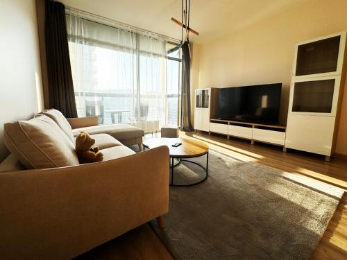 a living room with a couch and a tv at Riga Cozy Getaway - Near Airport in Rīga