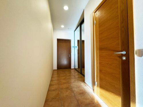 an empty hallway with a wooden door and a hallway at Riga Cozy Getaway - Near Airport in Rīga
