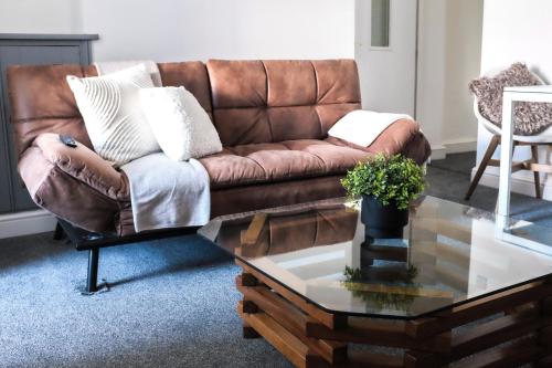a brown couch in a living room with a coffee table at #26b Renovated Portsmouth Flat in Portsmouth
