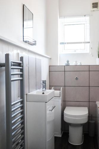a white bathroom with a toilet and a sink at #26b Renovated Portsmouth Flat in Portsmouth