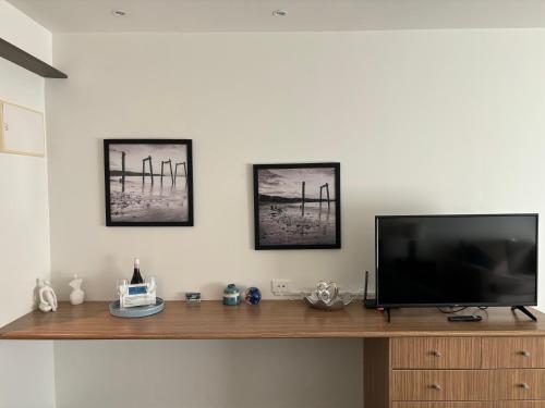 a flat screen tv sitting on top of a wooden entertainment center at Waterfront@Waves in Cowes