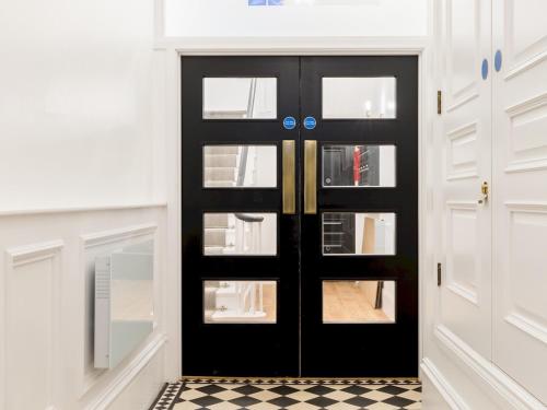 a black door in a room with a checkered floor at Pass the Keys Modern High End 1 Bed in Central Leamington Spa in Leamington Spa