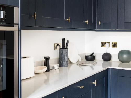 a kitchen with black cabinets and a white counter top at Pass the Keys Modern High End 1 Bed in Central Leamington Spa in Leamington Spa
