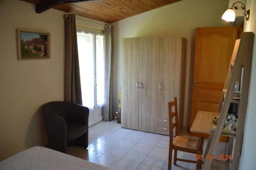 a room with a kitchen and a table and a door at Le chalet des Contries in Sarlat-la-Canéda