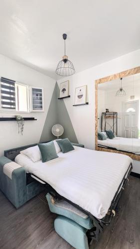 une chambre avec un grand lit et un miroir dans l'établissement *Ça me convient* Studio Chaleureux, à Villejuif