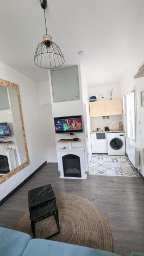 Il comprend un salon avec une télévision et une cheminée. dans l'établissement *Ça me convient* Studio Chaleureux, à Villejuif