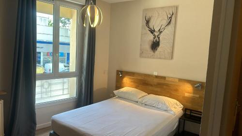 a bedroom with a bed with a deer picture on the wall at HOTEL IN PARIS in Aubervilliers