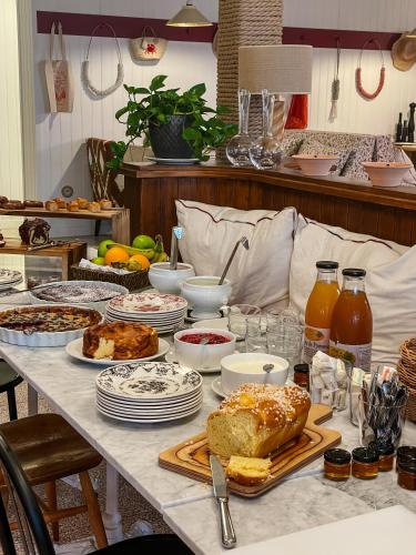 une table remplie de denrées alimentaires et de assiettes alimentaires dans l'établissement Hôtel de la Plage, à Lège-Cap-Ferret